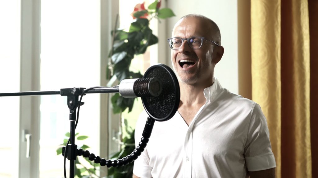 A man sings into the microphone. An example of online singing lessons.