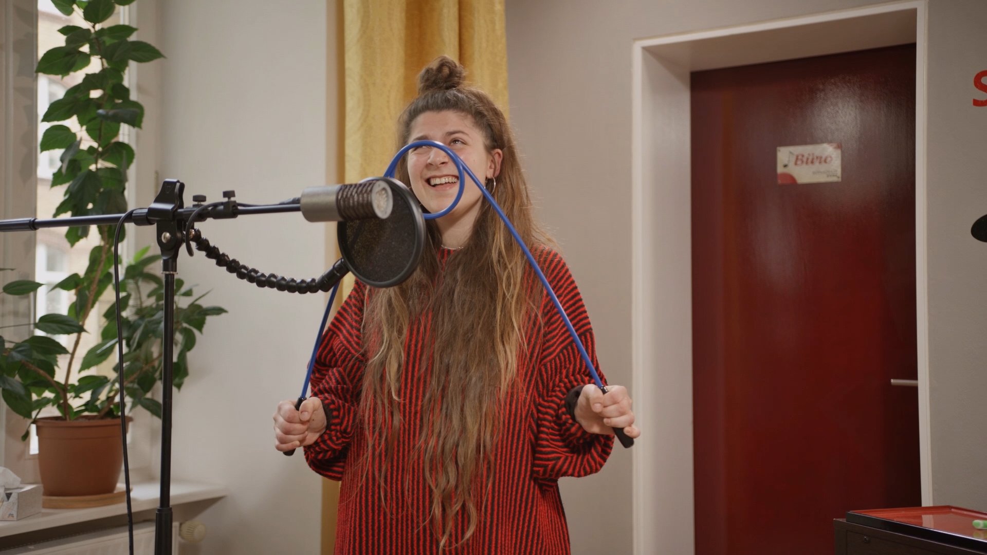 Eine Frau singt ins Mikrofon. Ein Beispiel für Online-Gesangsunterricht.